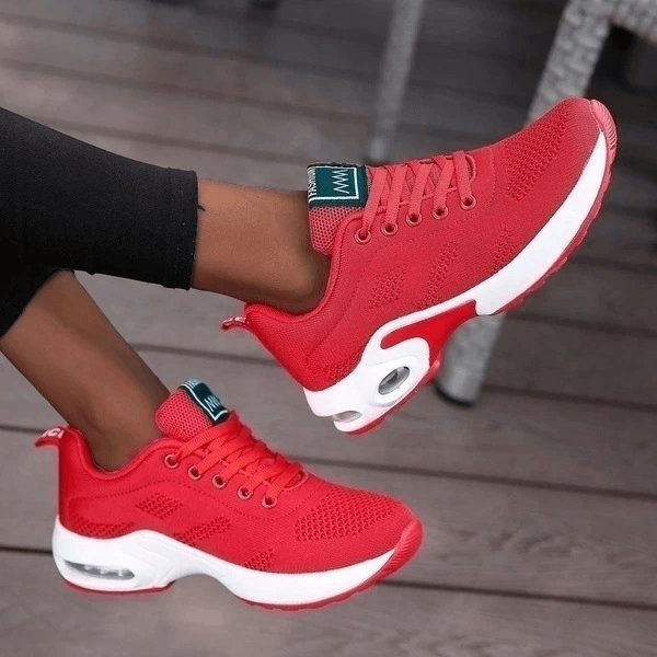 Red breathable mesh women's running shoes with lace-up closure and cushioned insole for comfort and support.